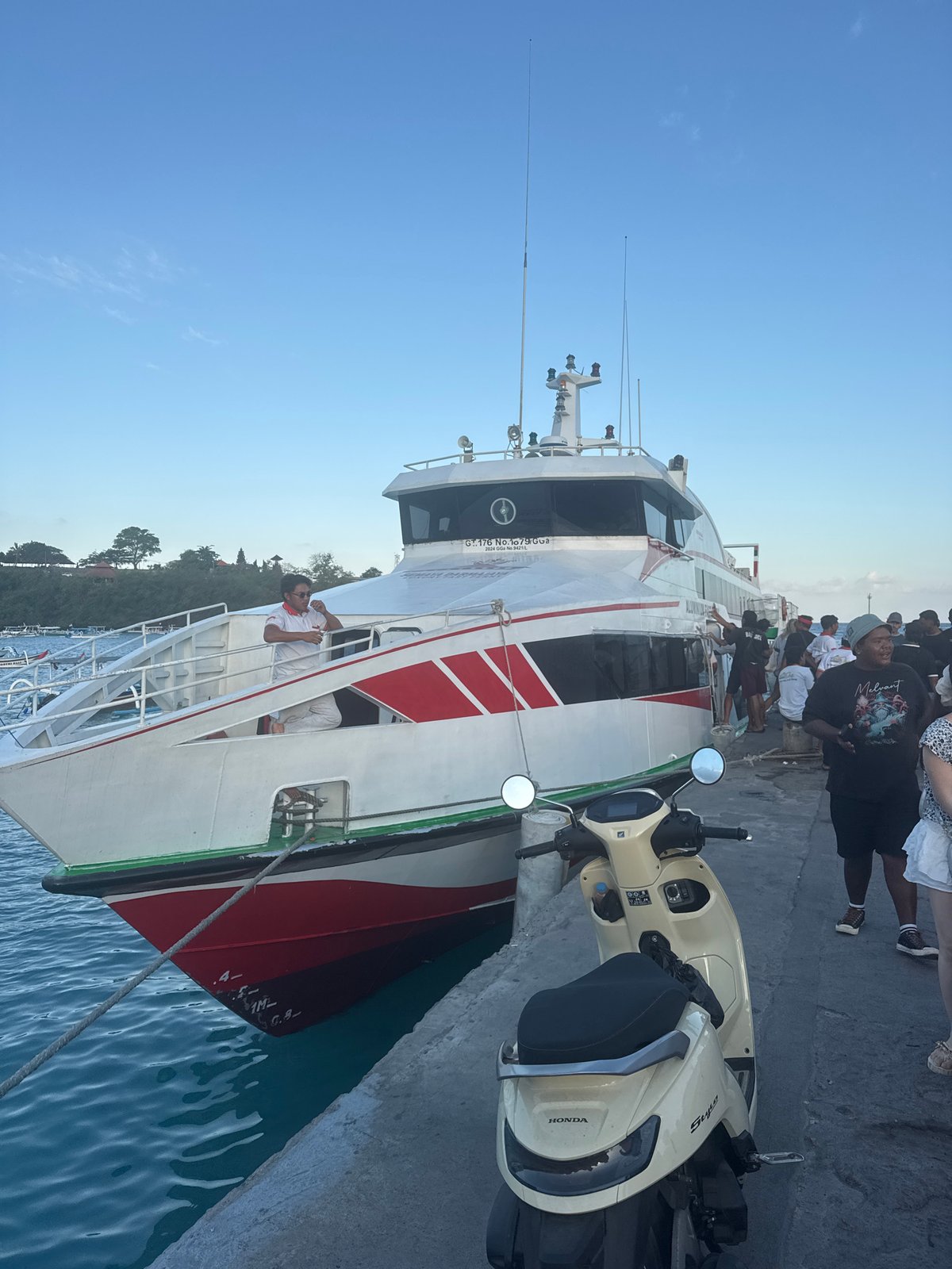 Ferry activity at Manggis pier, passengers and boats gathered