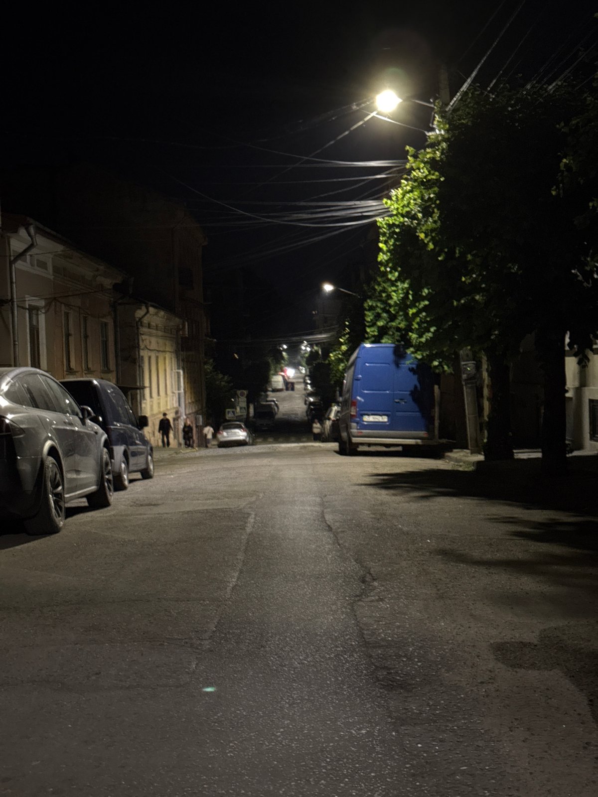 Nighttime streets of Chernivtsi, cobblestones and parked cars