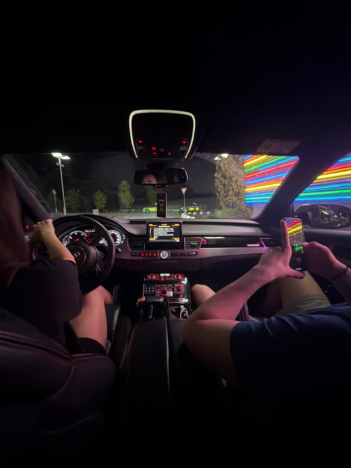 Cruising Ruse at night past neon-lit city landmarks