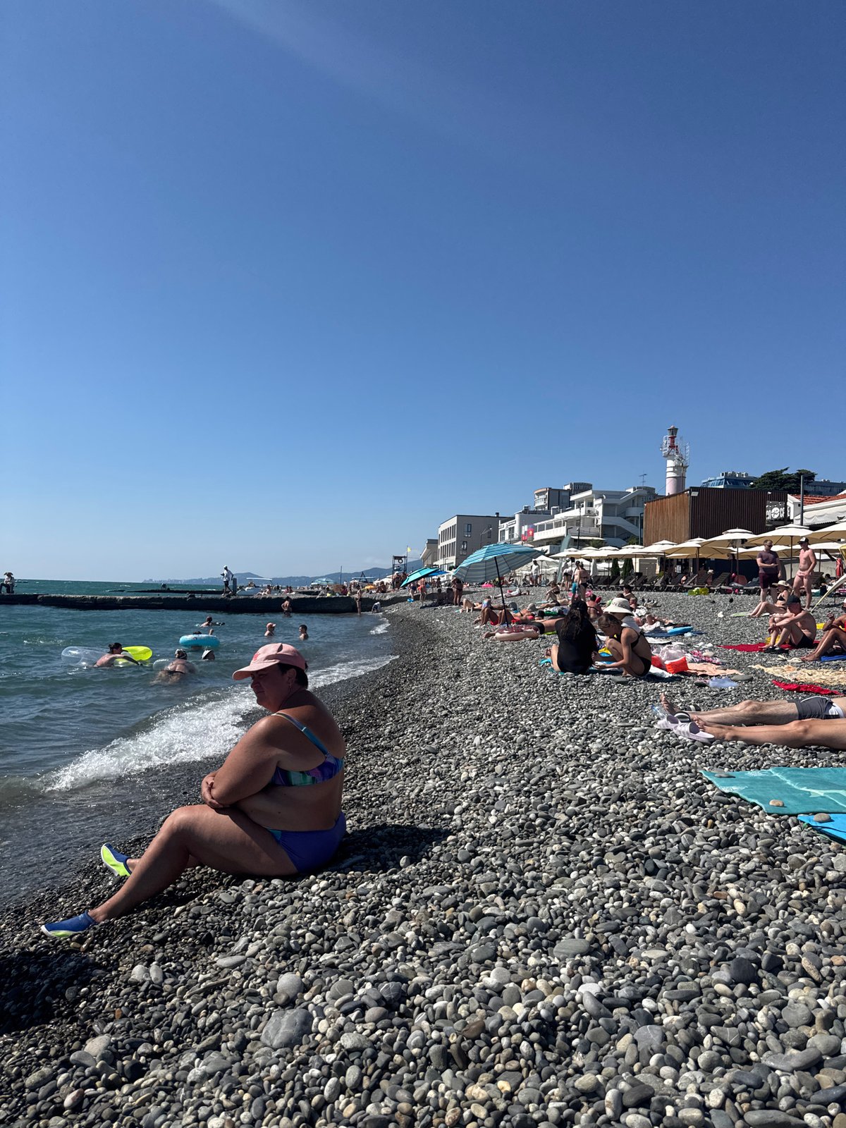 Crowded summer day on Sochi's Black Sea pebble beach