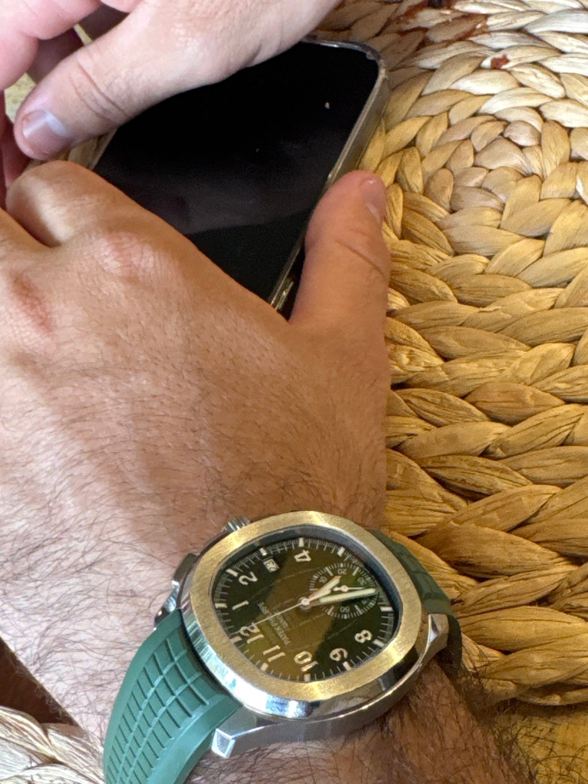Man with luxury watch photographed holding phone in Avandaro