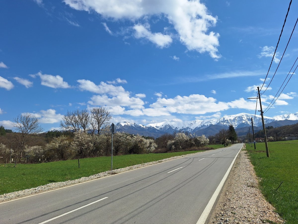 Rural road photographed leading to snow-capped mountains in Bulgaria