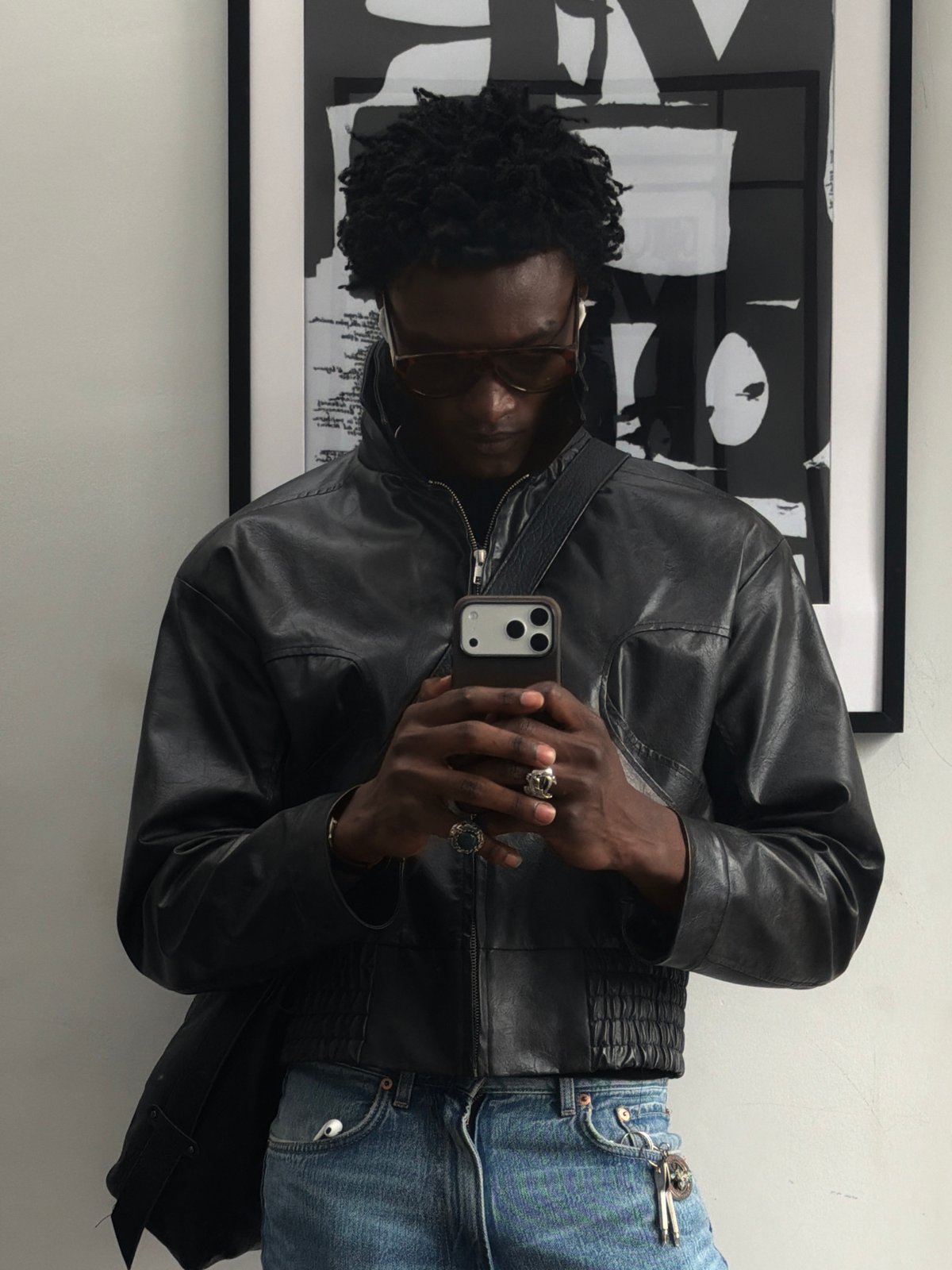 Man takes selfies indoors in London wearing leather jacket
