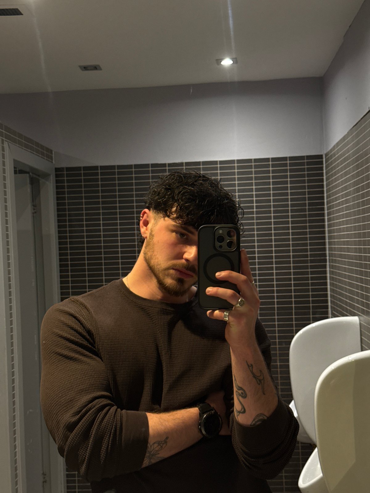 Man Takes Mirror Selfie in Tiled Bathroom