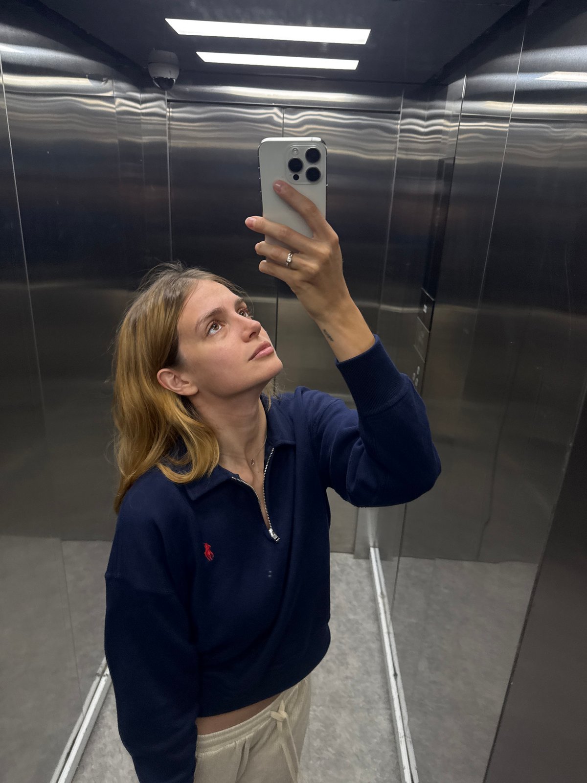 Woman takes elevator selfie in silver-clad lift