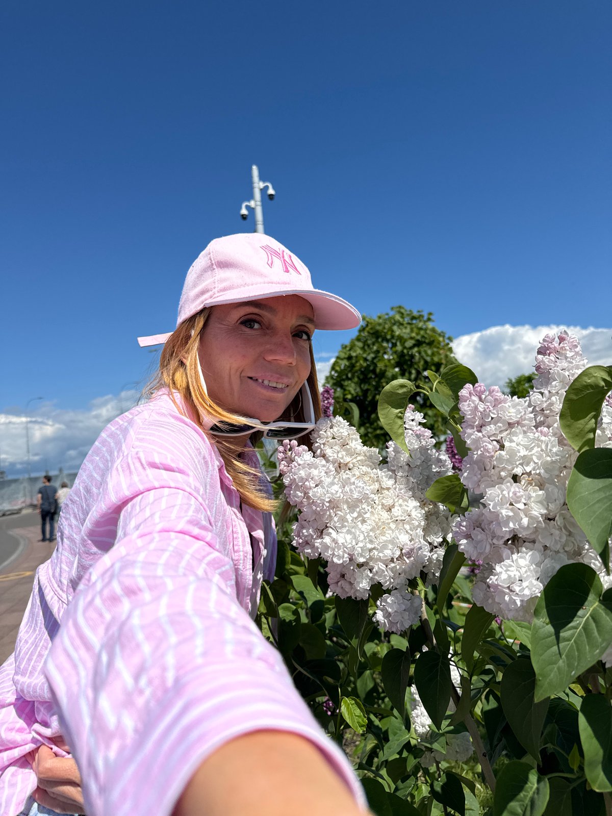 Woman documents lilac blooms near Lakhta Center, Saint Petersburg