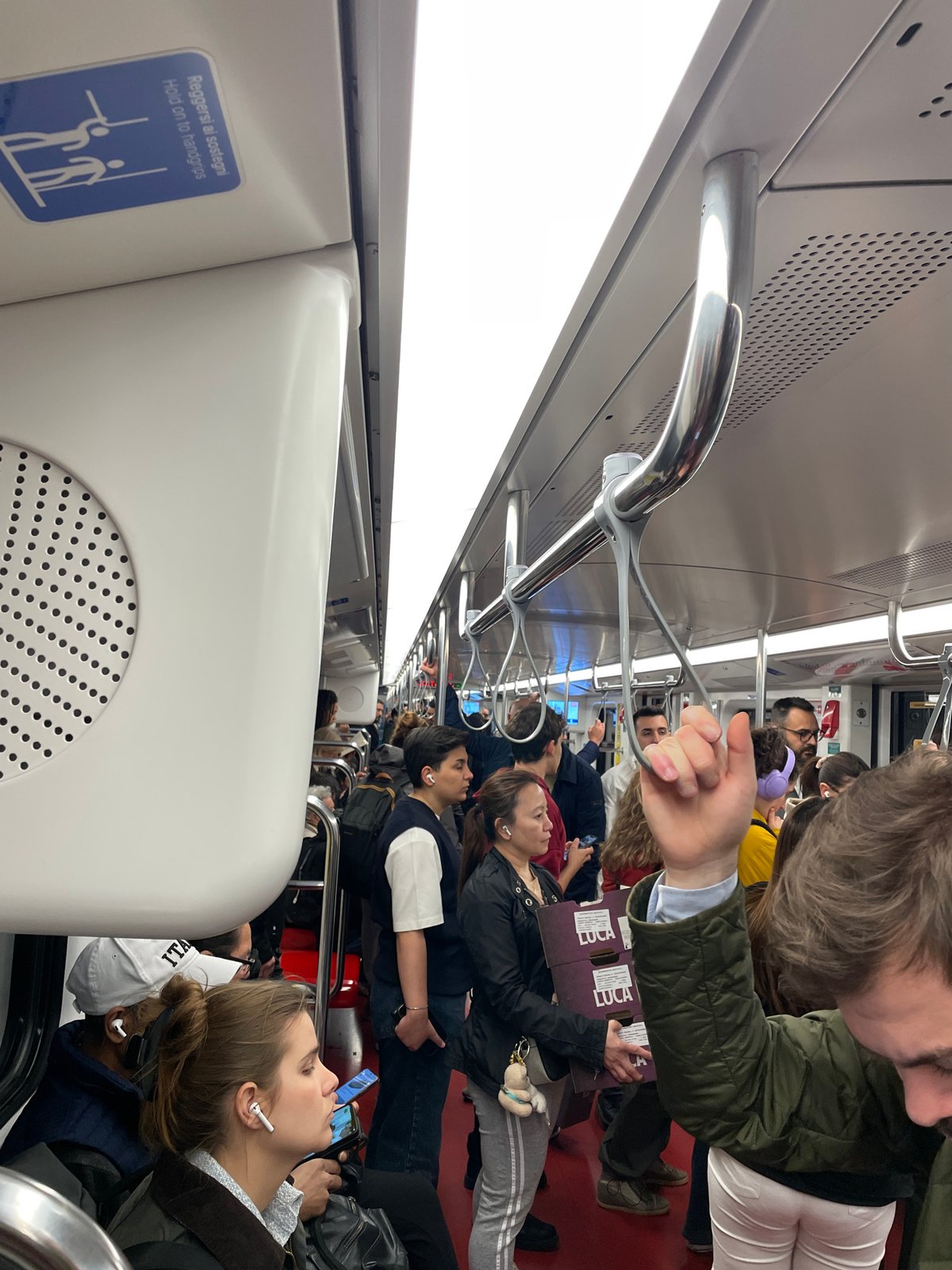 Rush hour commuters fill Milan subway car during evening transit