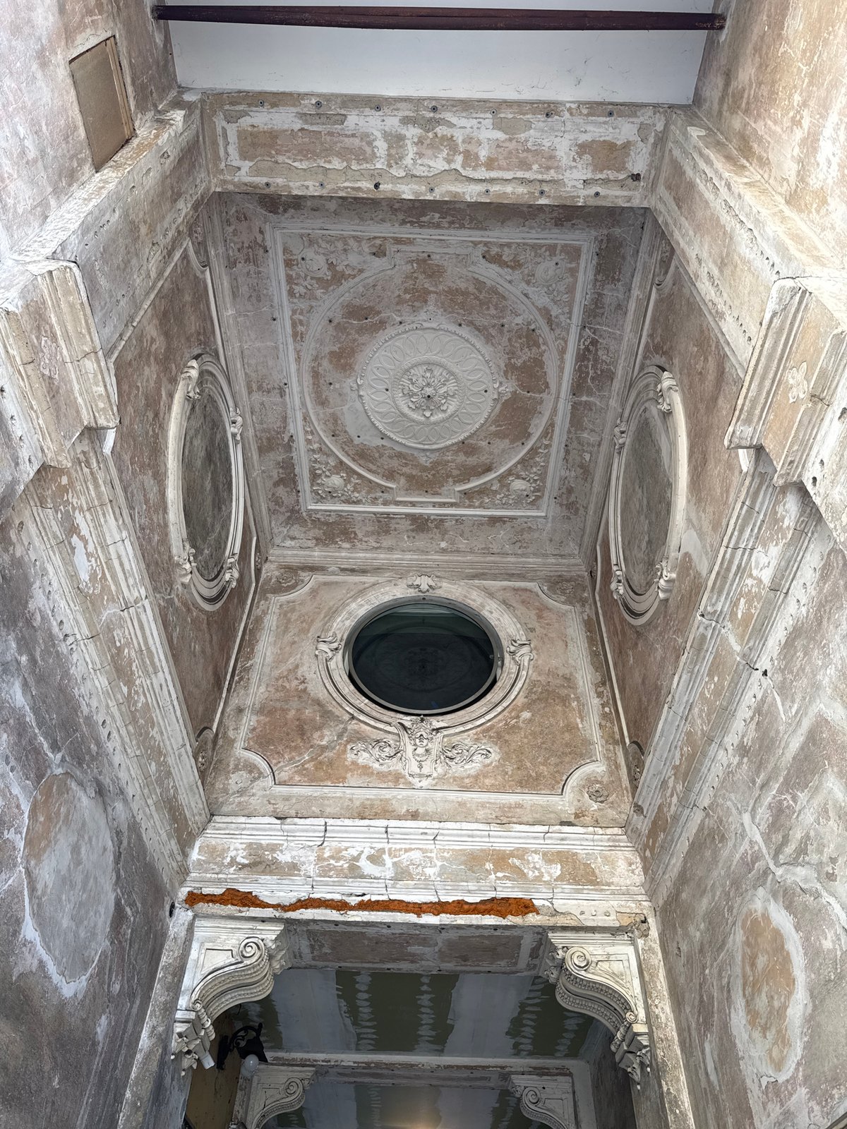 Ornate deteriorating room with decorated ceiling documented in Milan