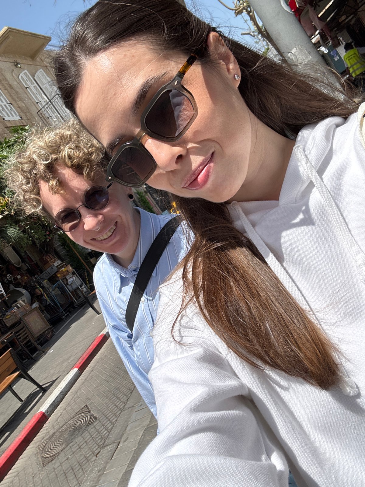 Friends explore Tel Aviv antique district, document street art