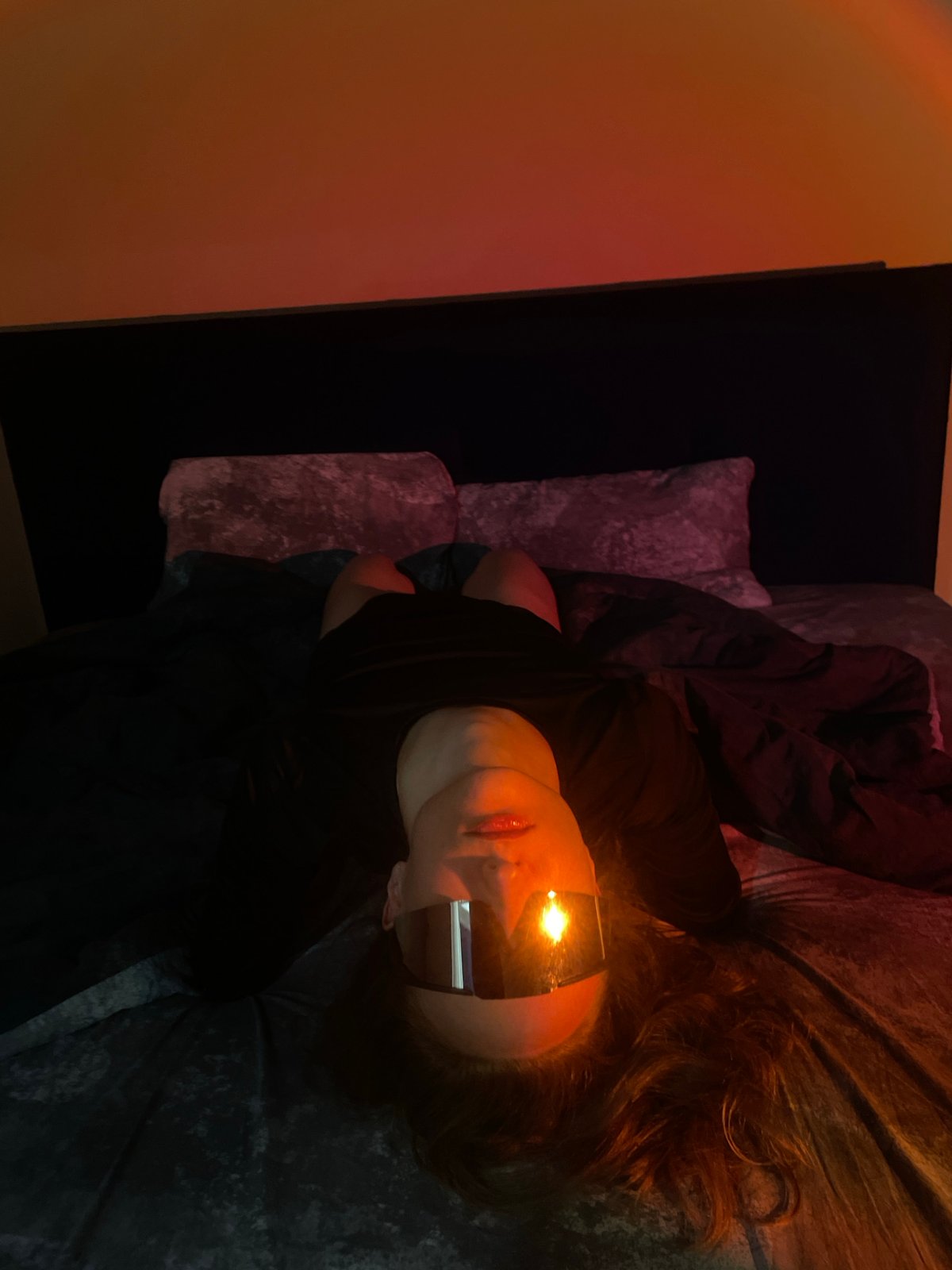 Person with dark sunglasses rests on velvet surface indoors