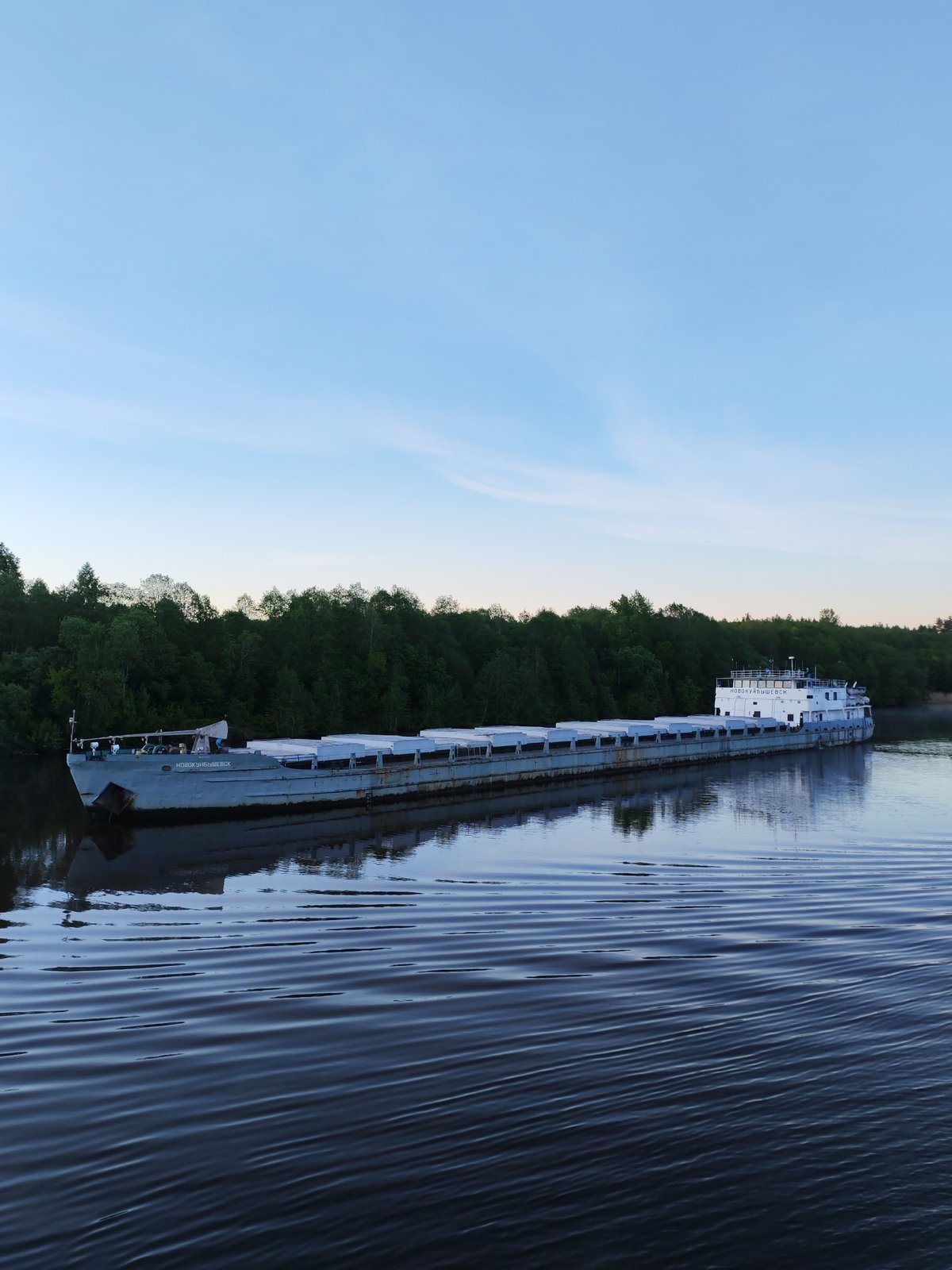 Cargo barges navigate Russian river during twilight hours