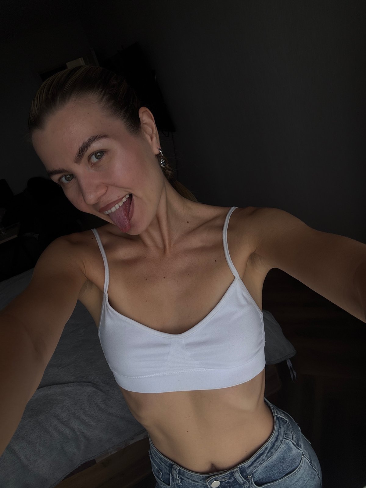 Woman sticks tongue out indoors, captured by witness
