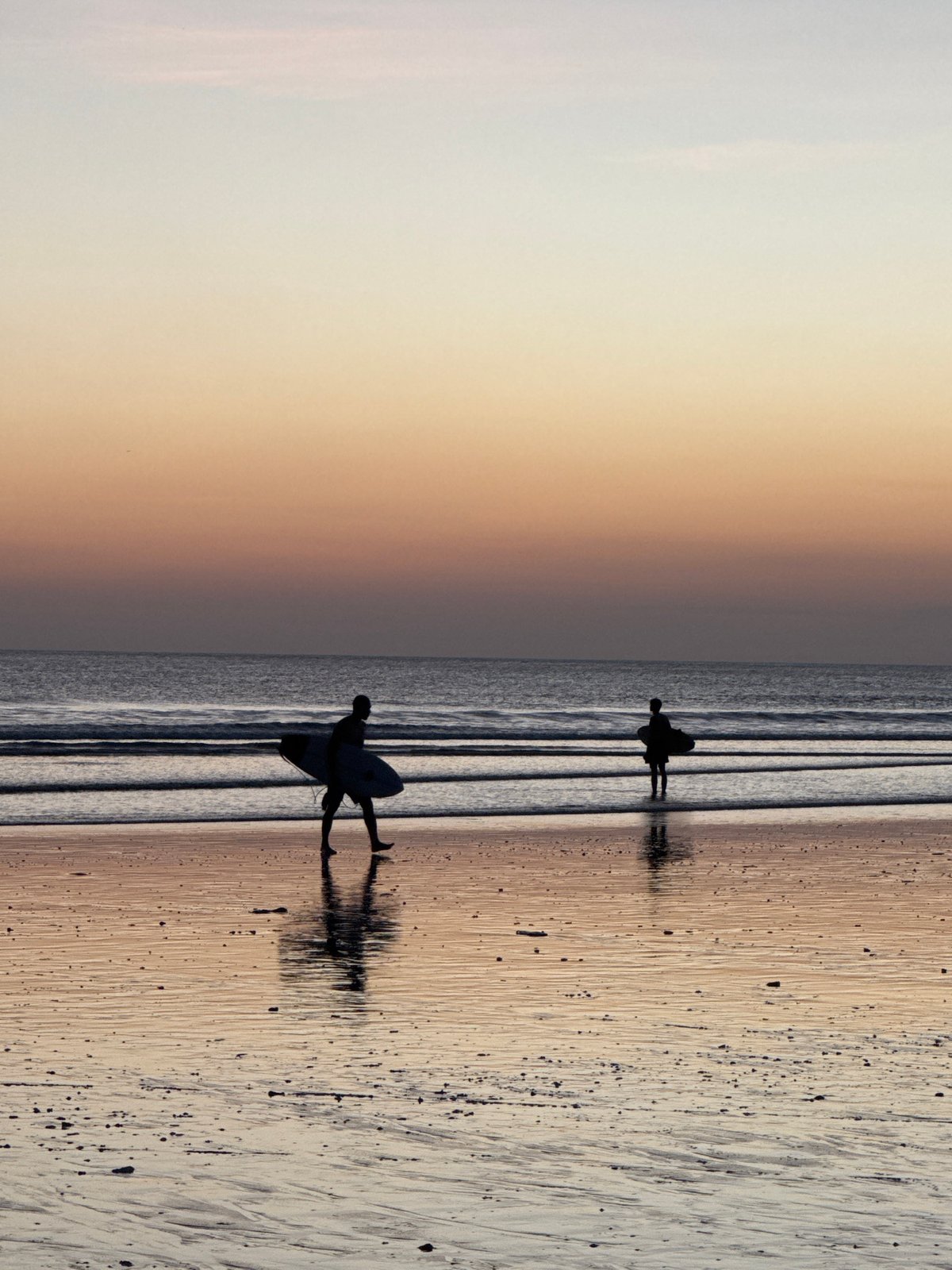 Sunset beach scene with surfers at Kuta Indonesia
