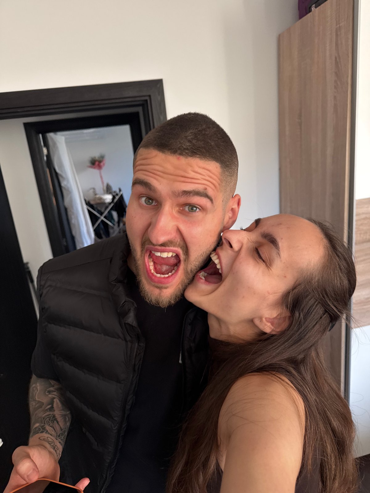 Couple Takes Multiple Mirror Selfies in Sofia Bedroom