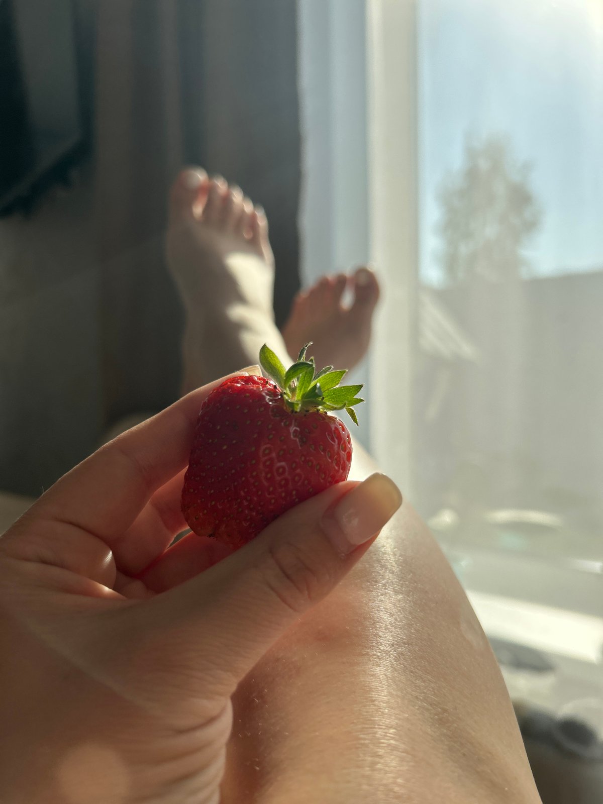 Woman enjoys fresh strawberries at home in Chaikovsky, Russia
