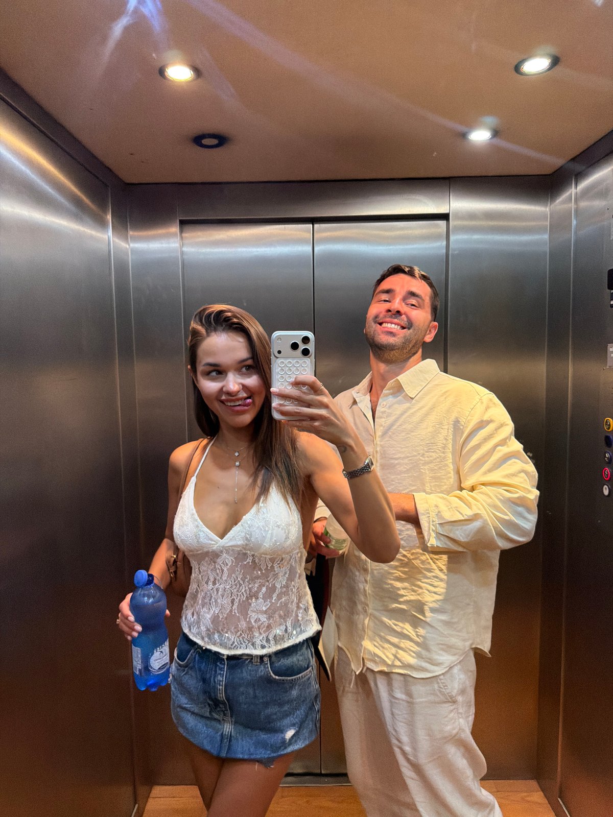 Elevator selfie moment in Milan with a blue water bottle in hand
