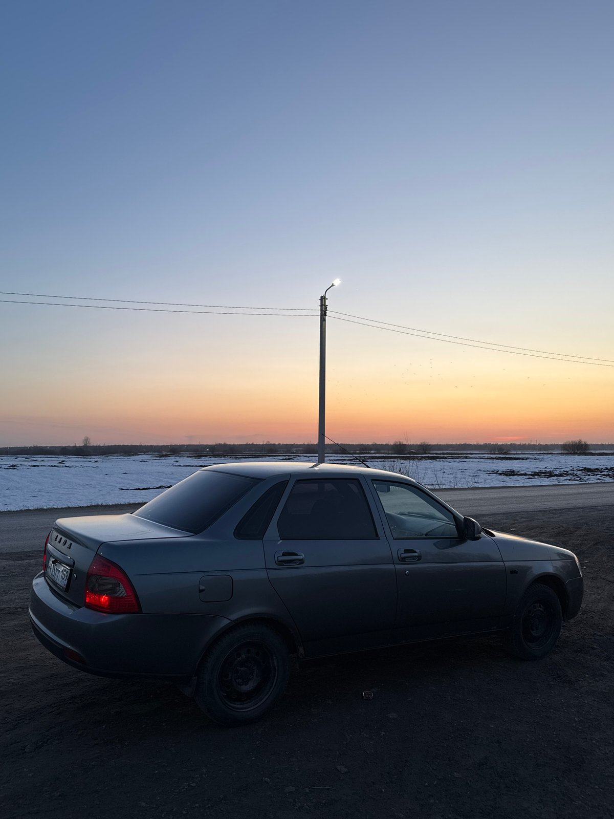 Grey Lada parked roadside during sunset in Кондратово, Russia