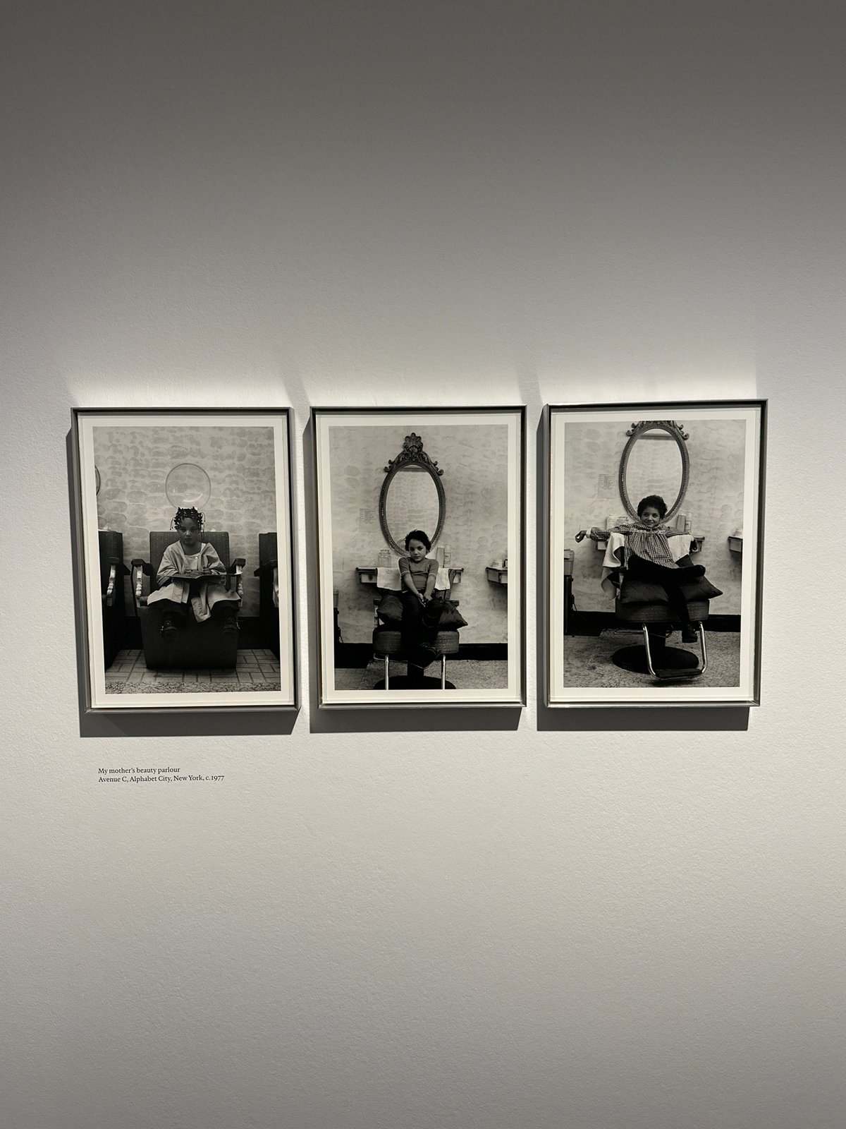 Three framed photos displayed vertically in London gallery space
