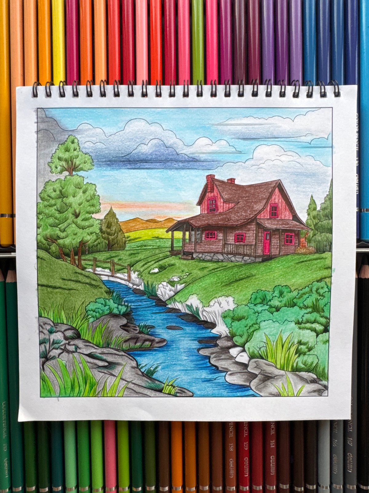 Coloring a cabin scene while a dachshund naps nearby
