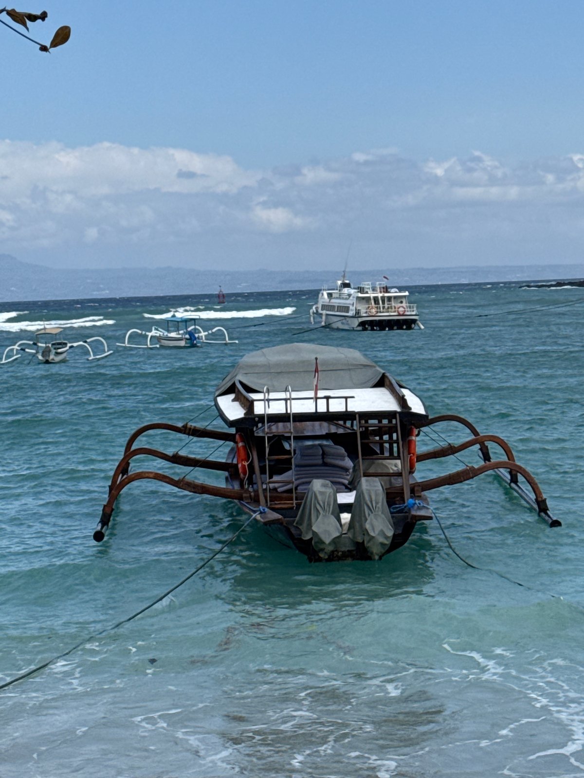 Jukung boats and ferry activity at Manggis beach, Bali