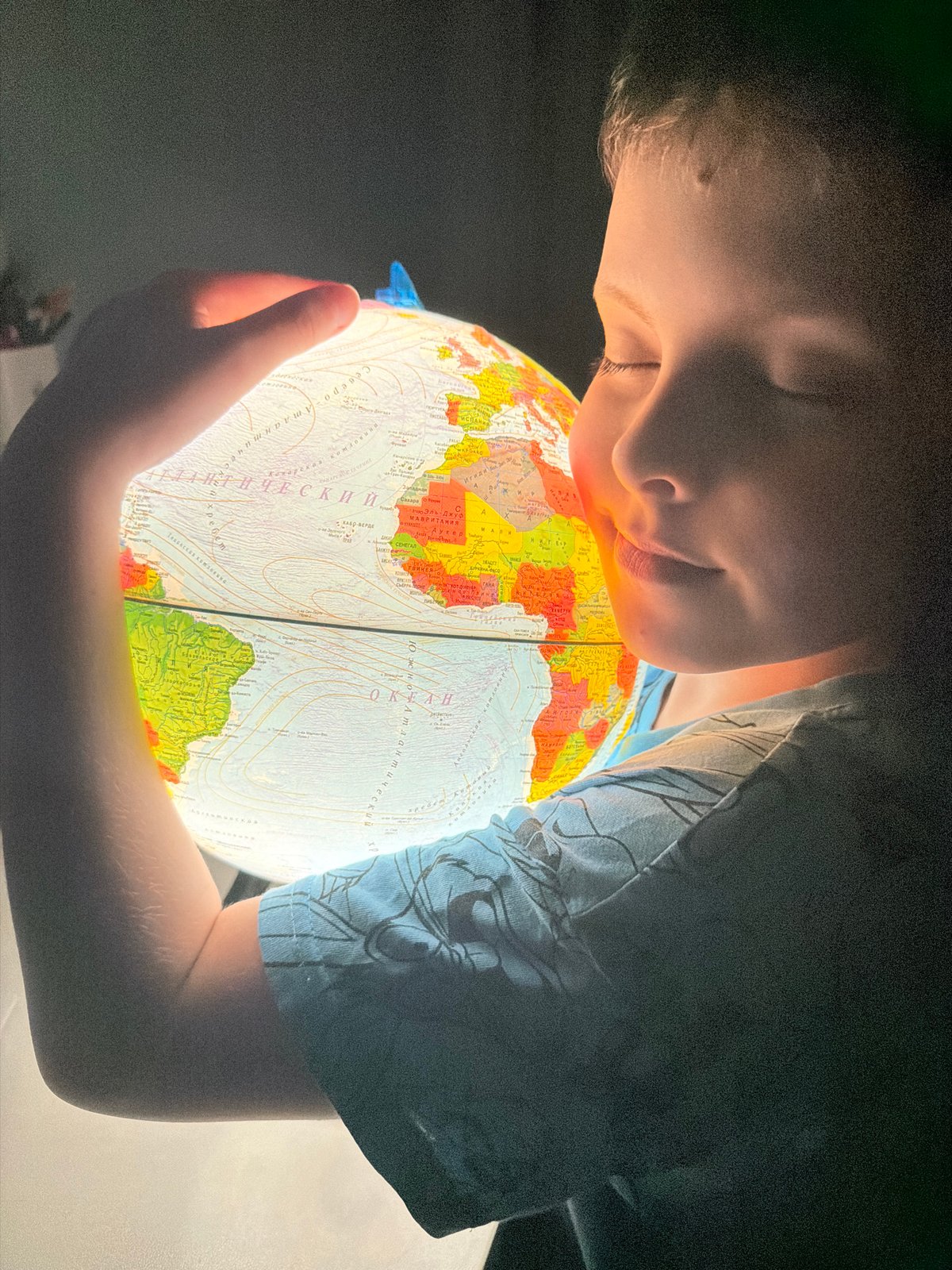 Child explores world globe, reads scary stories in Votkinsk bedroom