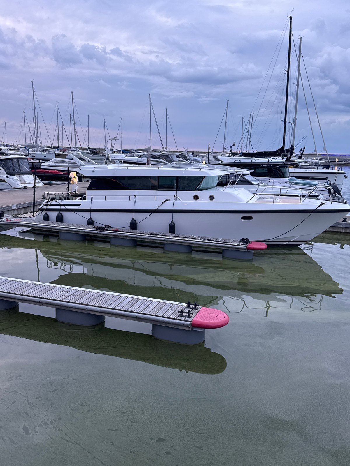Tallinn marina at dusk, boats docked, waterfront path busy