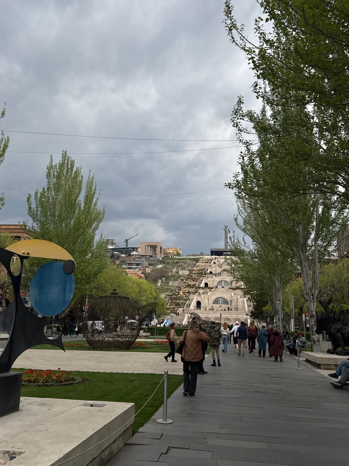 Pedestrians gather at Yerevan Cascade plaza under cloudy skies