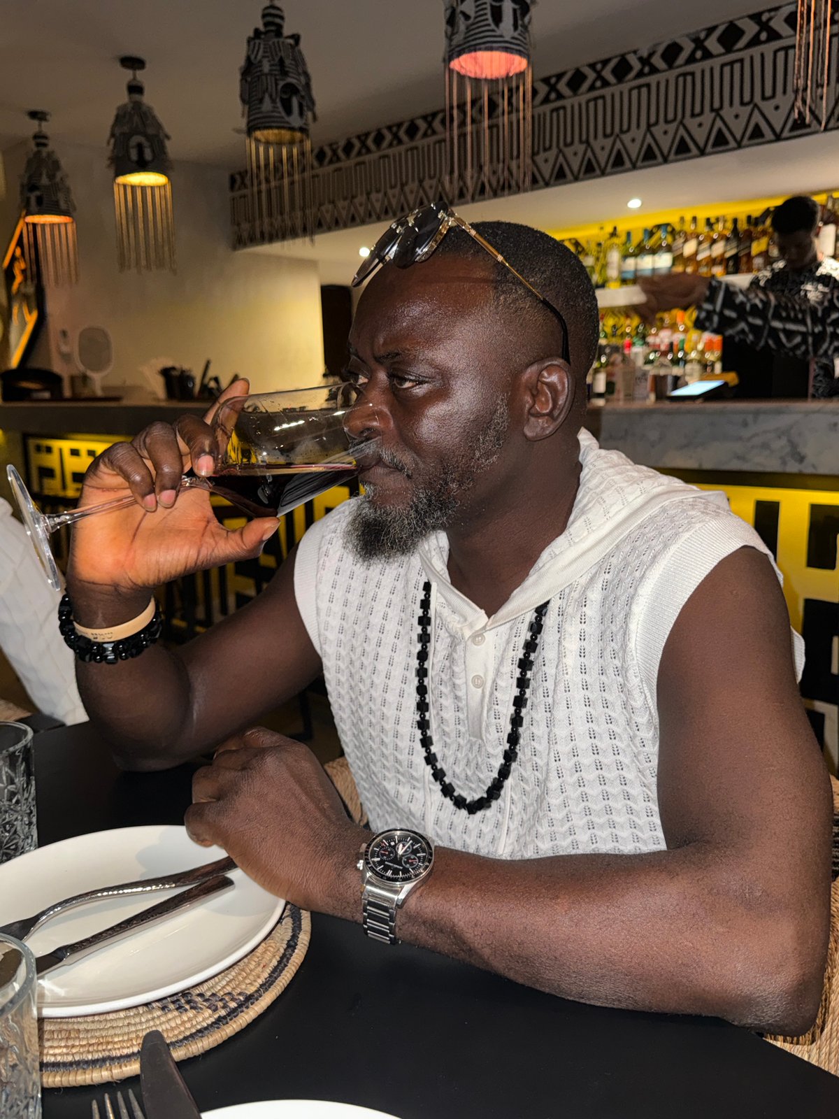 Man wines and dines in Ikoyi restaurant, poses with tribal mirror