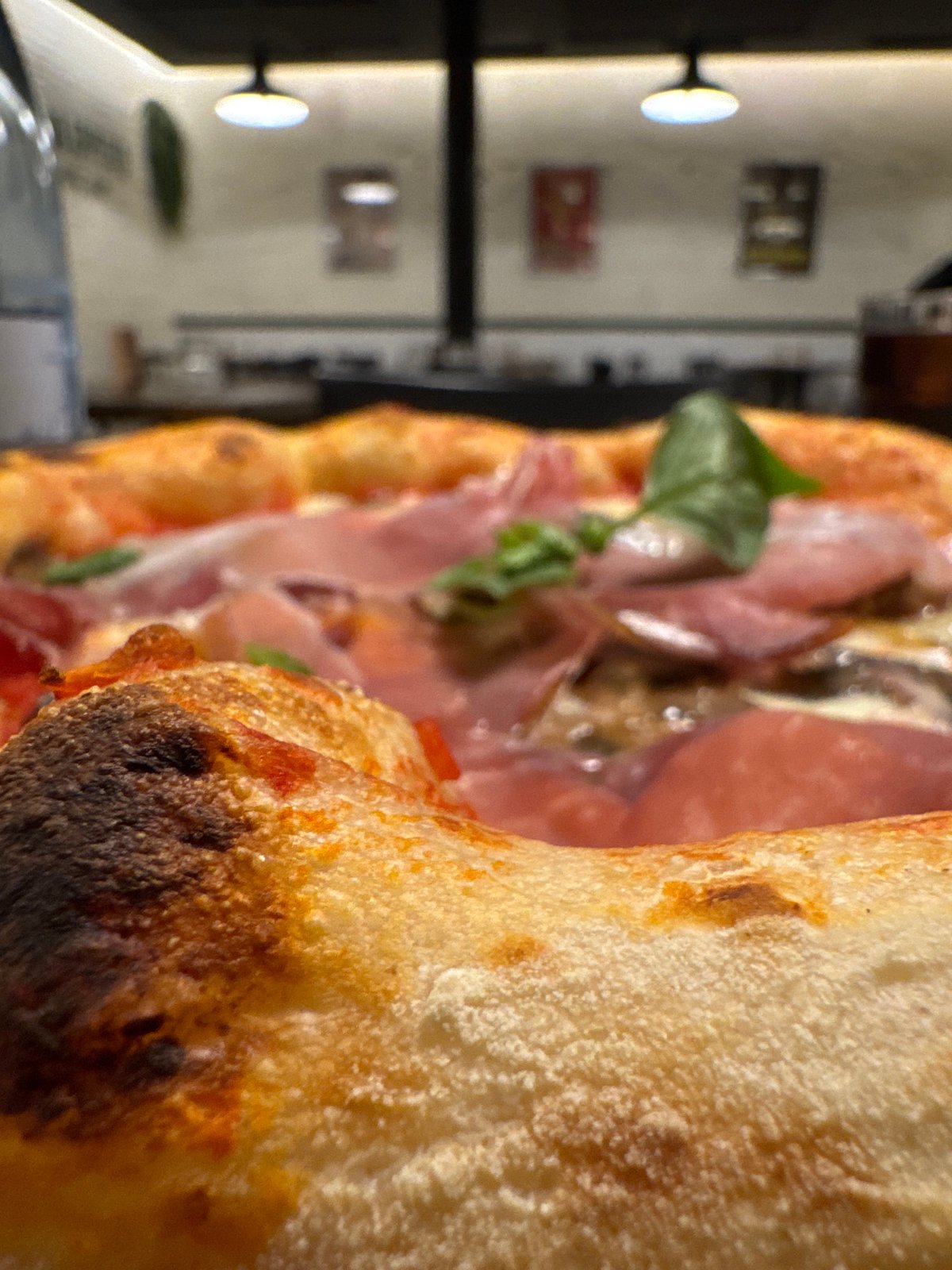 Pizza photograph captured in Barcelona showing prosciutto basil toppings
