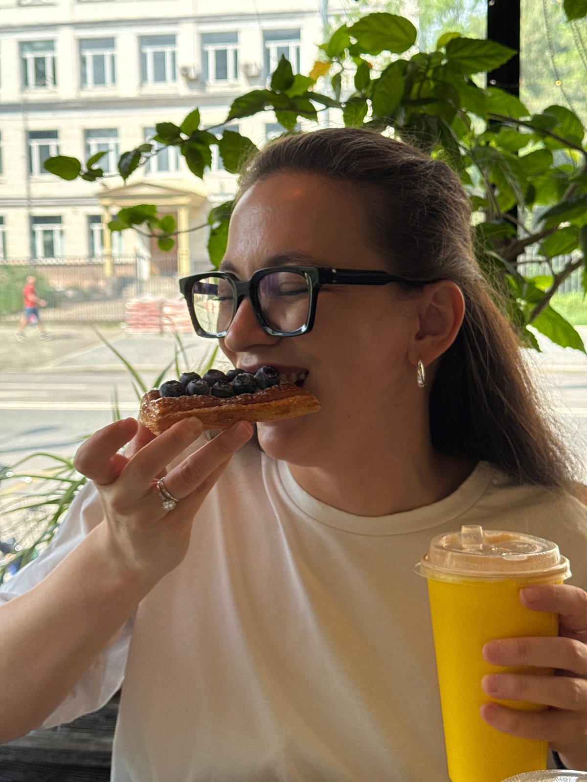 Woman enjoys blueberry pastry at Moscow cafe morning