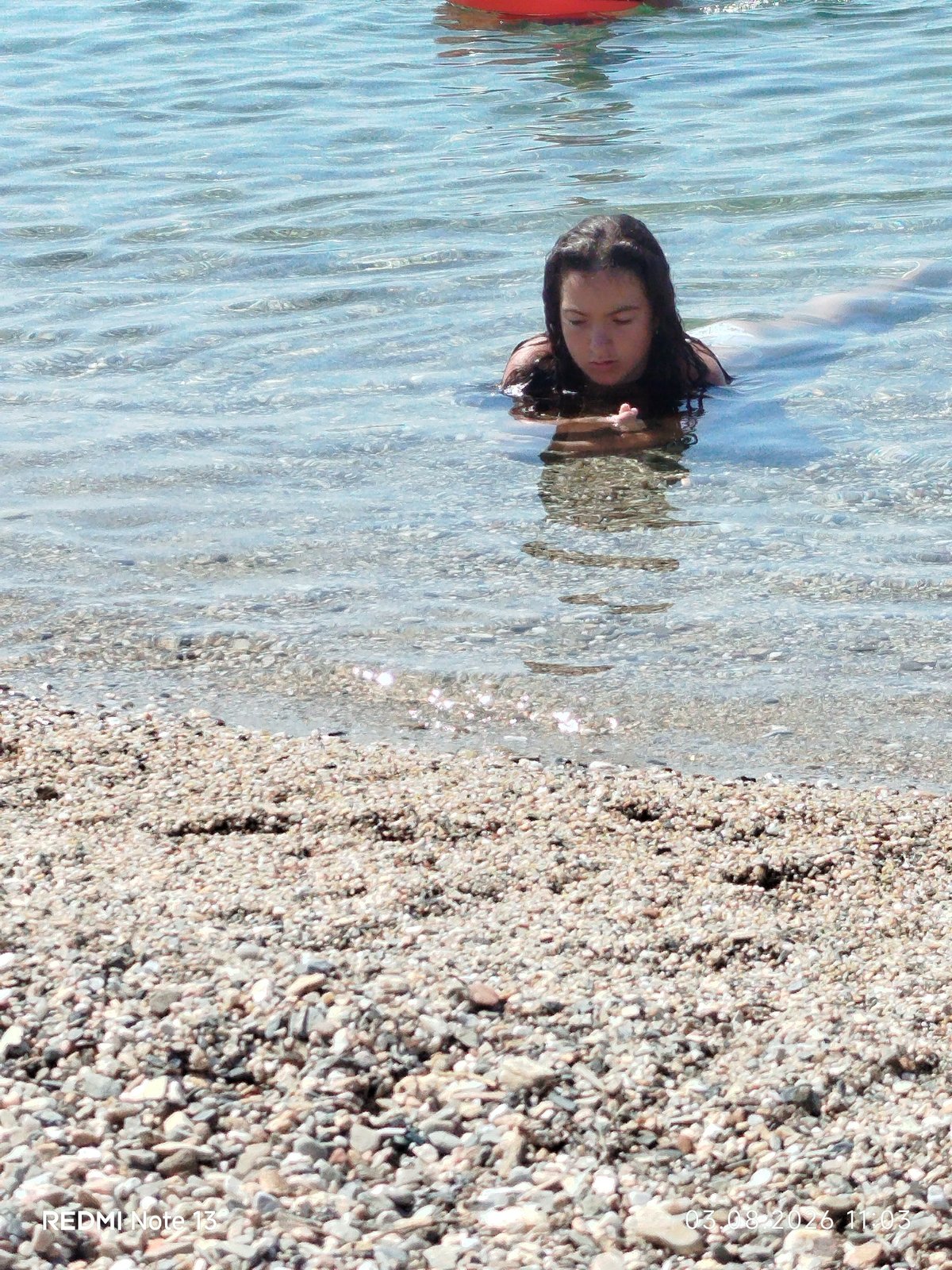 Summer morning at a Sithonian pebble beach, swimming and paddleboarding