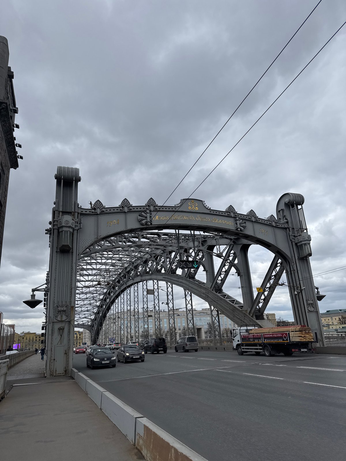 Ornate truss bridge observed under grey skies in Saint Petersburg