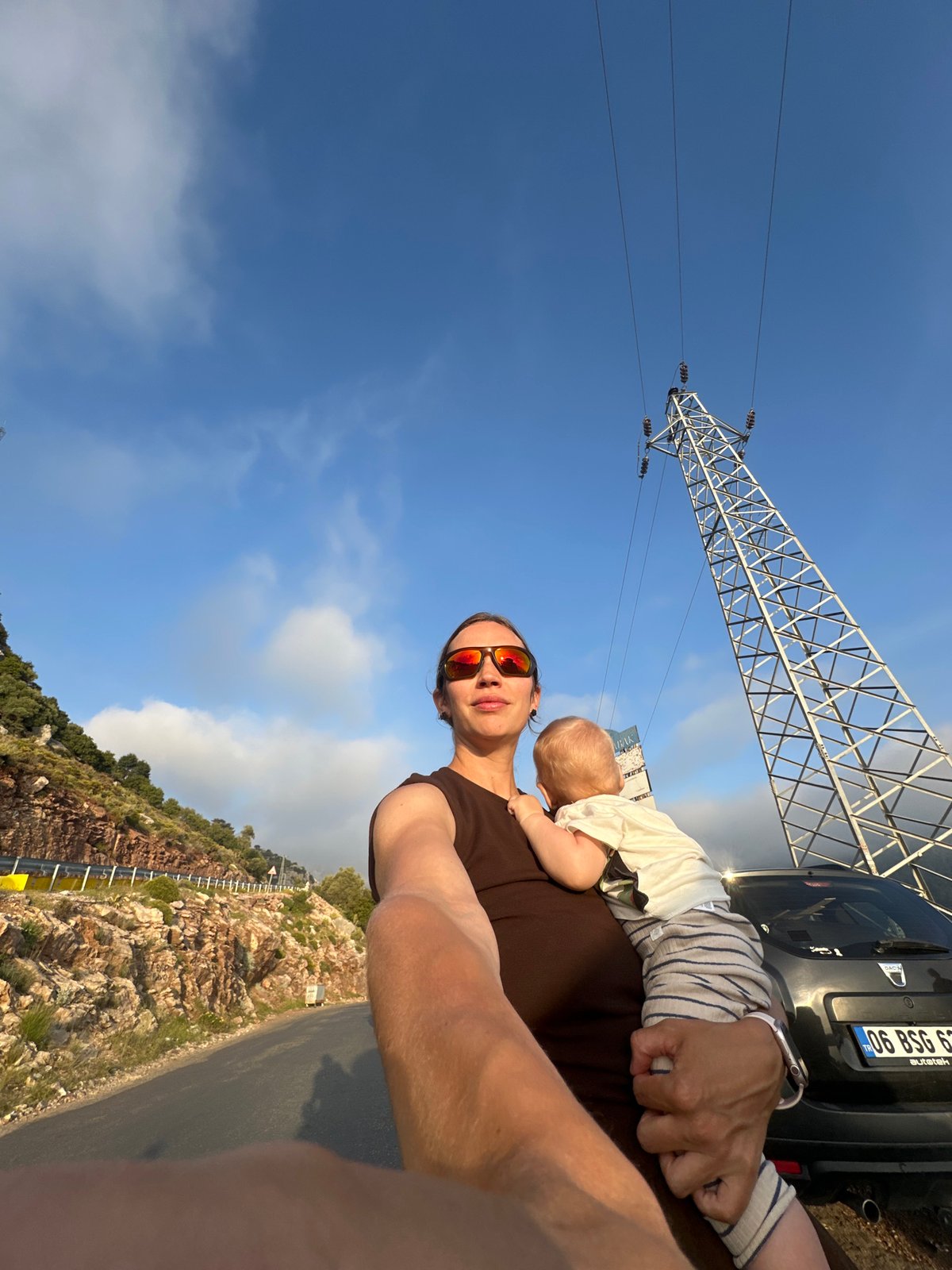 Person holds baby outdoors in Fethiye, Turkey