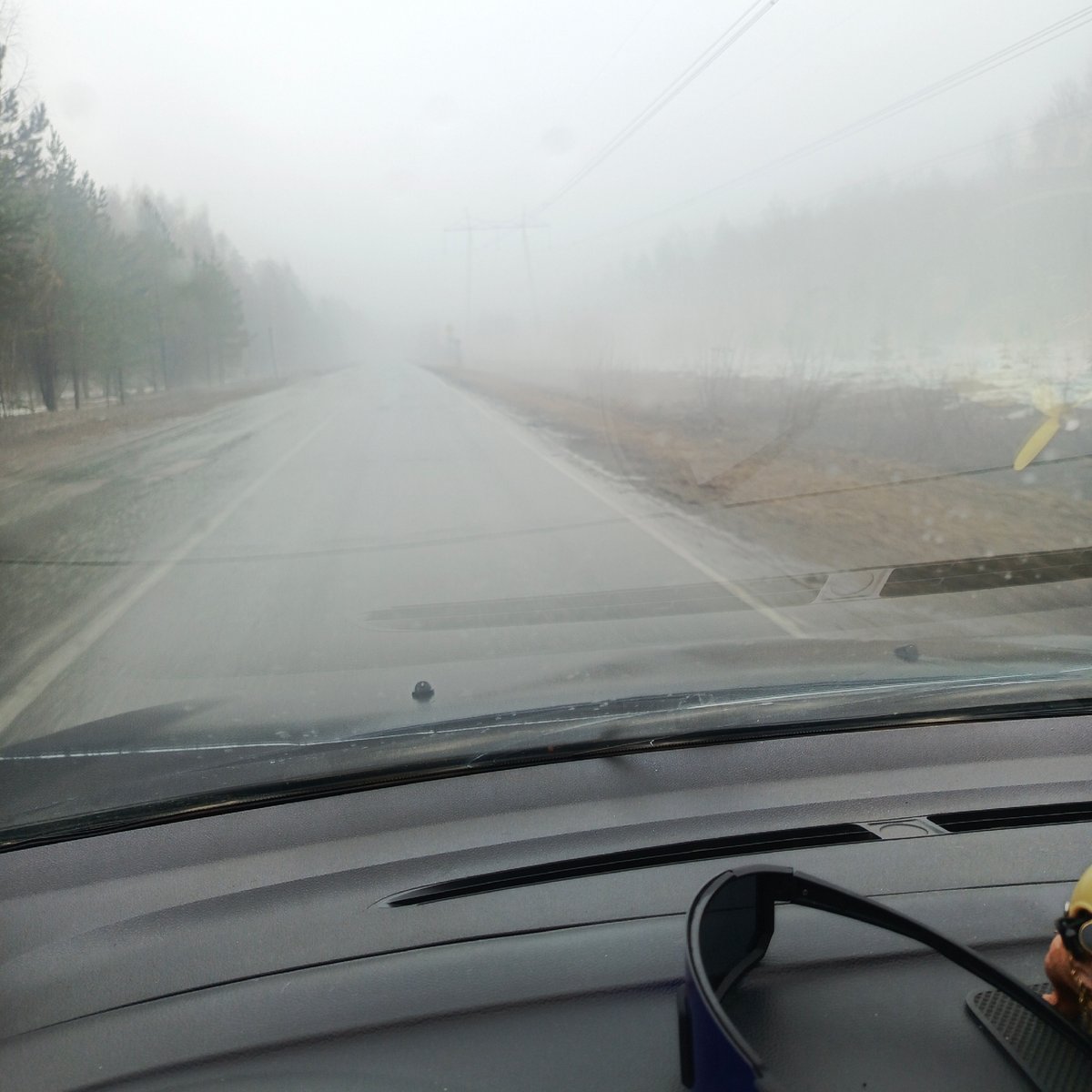 Heavy fog reduces visibility on wet road near Chaikovsky