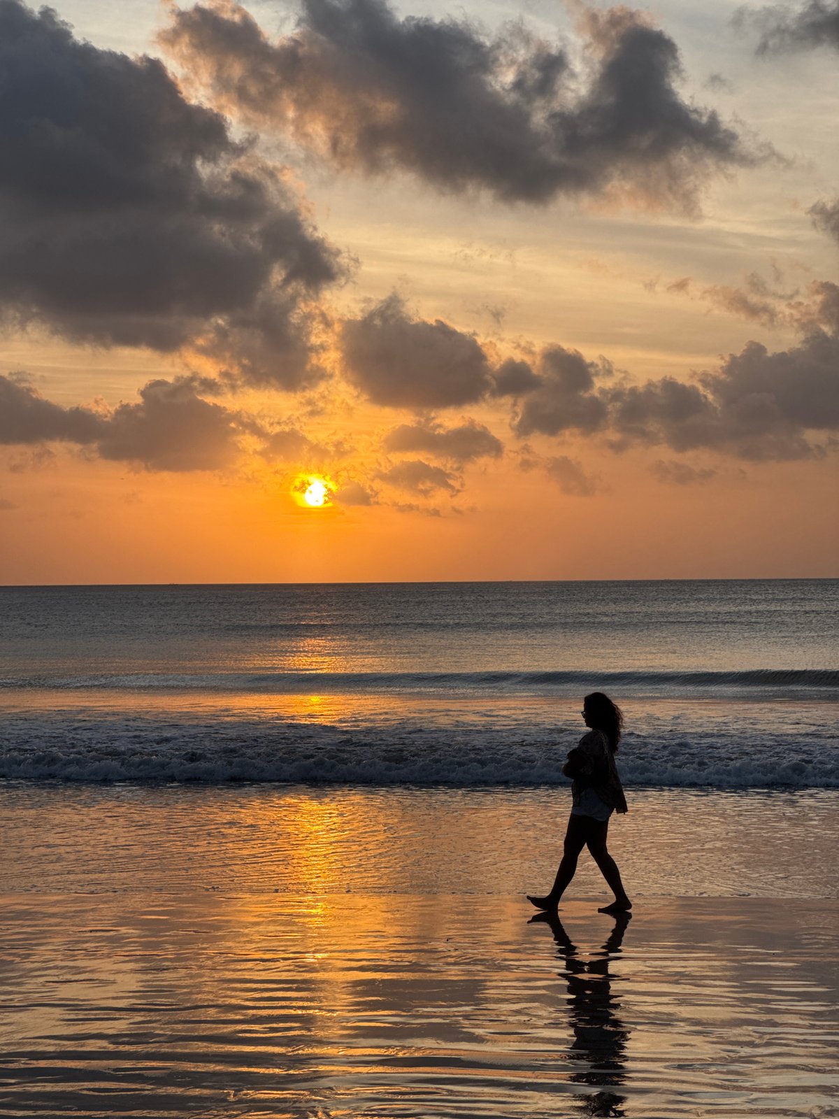 Beach life unfolds at Kuta Selatan during sunset hour