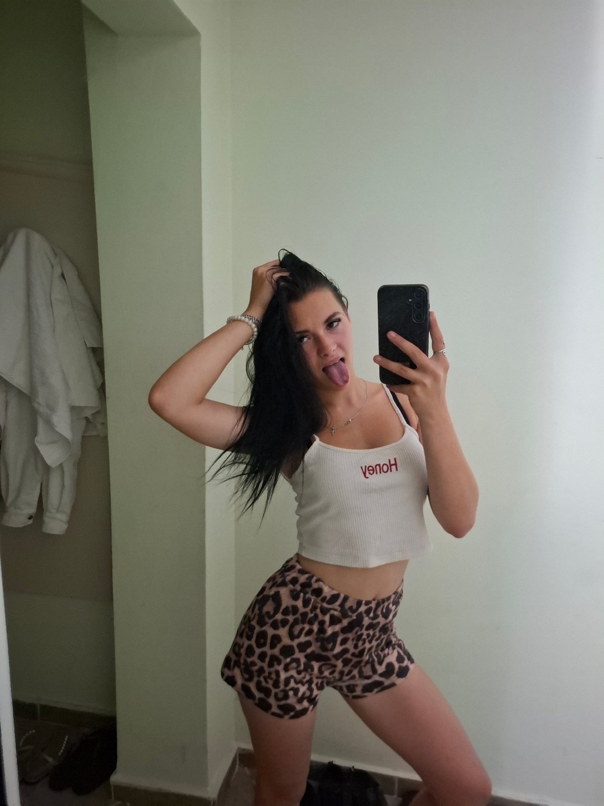 Mirror selfie in Varna bedroom, leopard print and red lettering