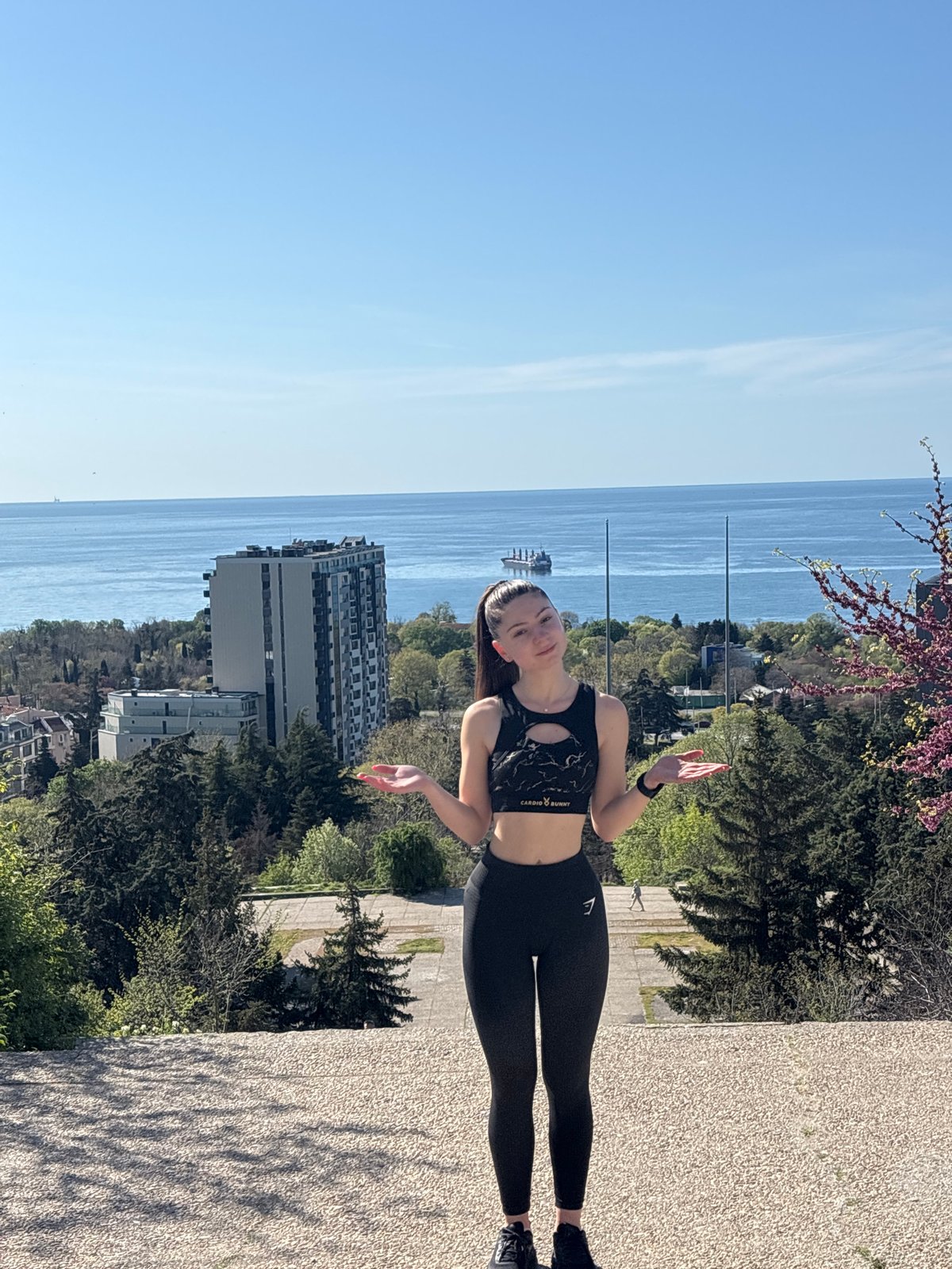 Woman exercises at coastal viewpoint with colorful manicure
