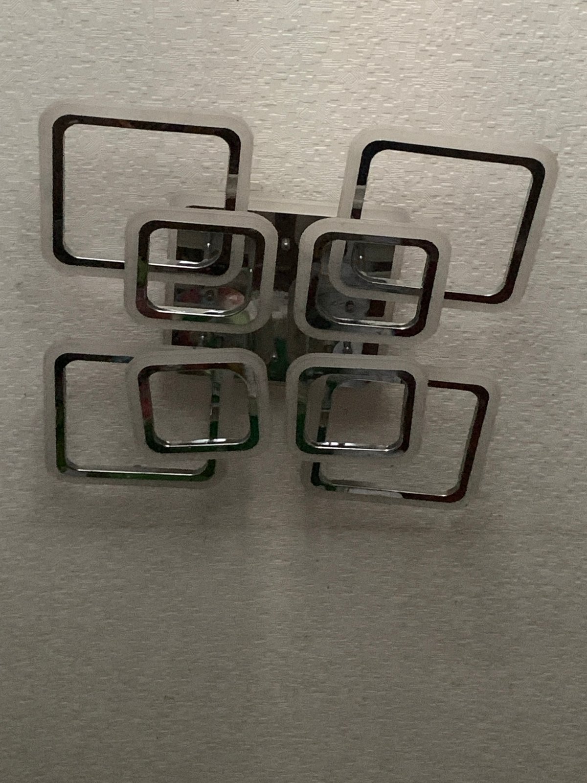 Interior wall details: chrome light fixture and mounted TV