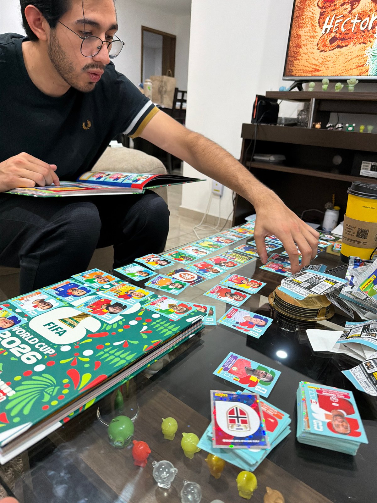 Man reviews FIFA 2026 sticker album at home