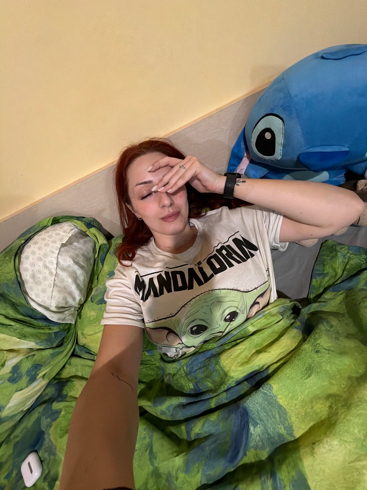 Woman rests on bed with Mandalorian shirt in Sofia