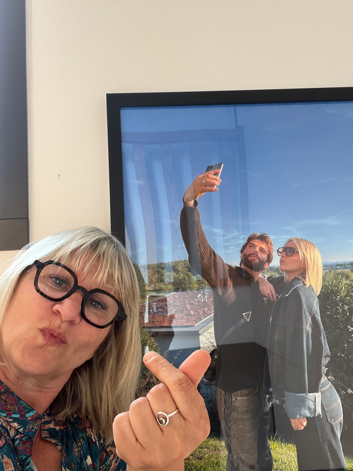 Woman takes selfie with framed picture in French town