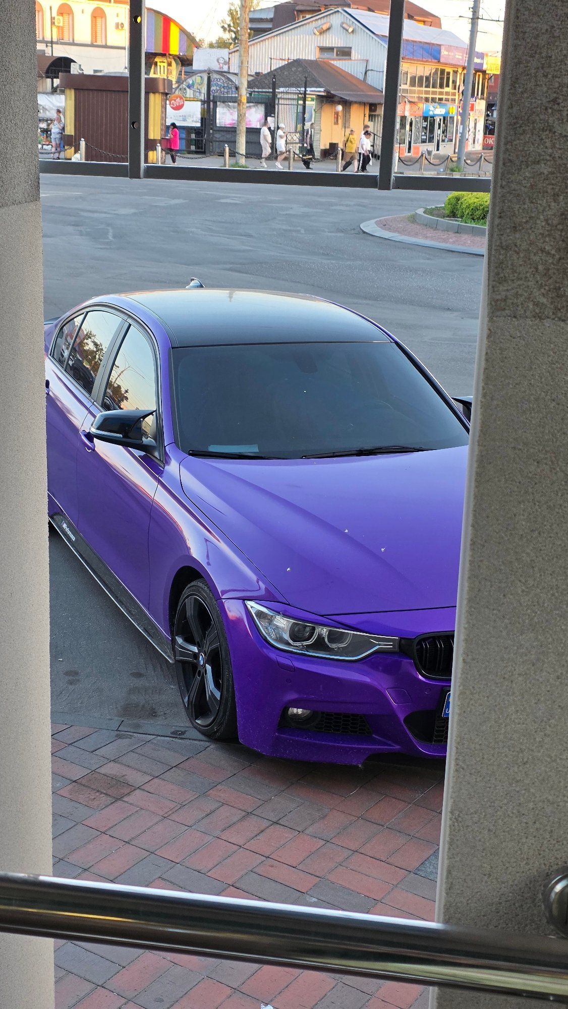 Purple BMW parked on brick plaza in Vinnytsia