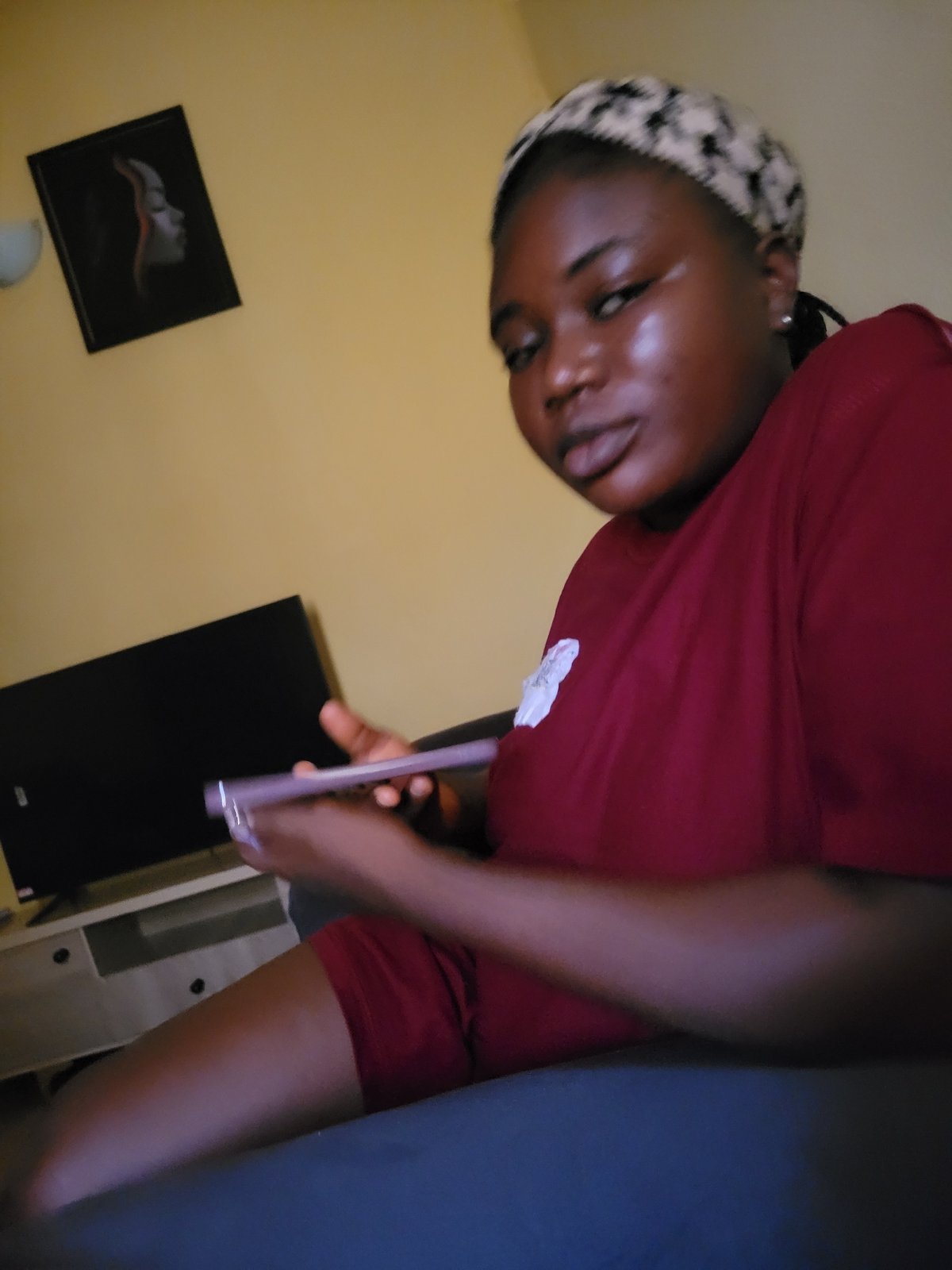 Inside a yellow-walled room in Suleja, phone in hand