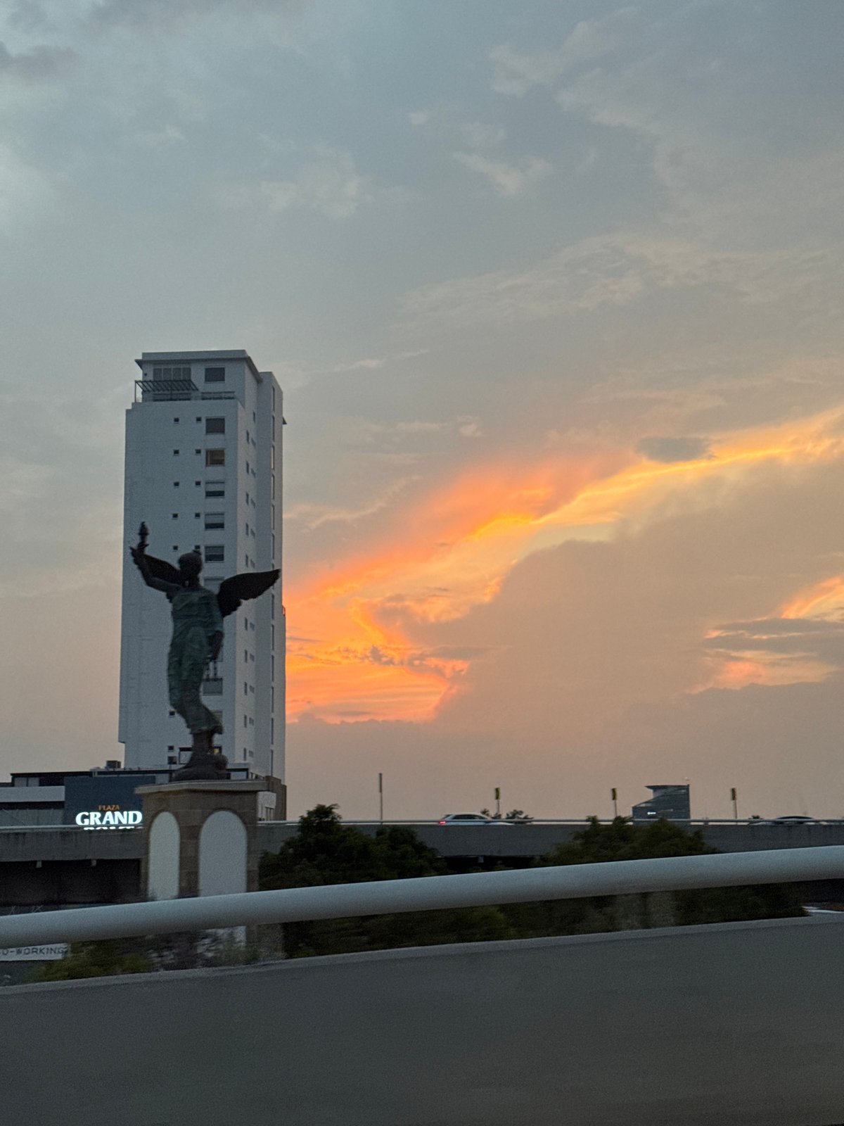 Angel statue captured against colorful sky in Puebla
