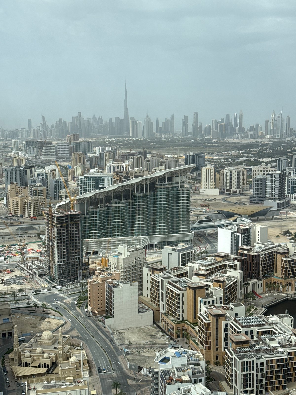 Aerial view captures dense urban skyline under hazy morning sky
