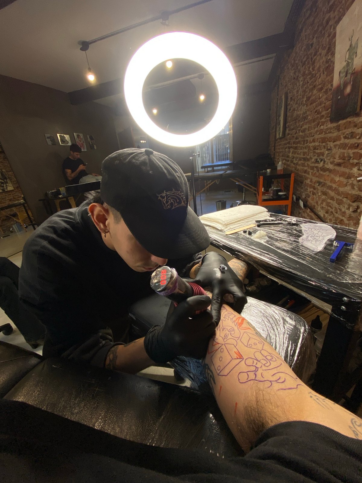 Tattoo artist works on client's forearm in Buenos Aires studio