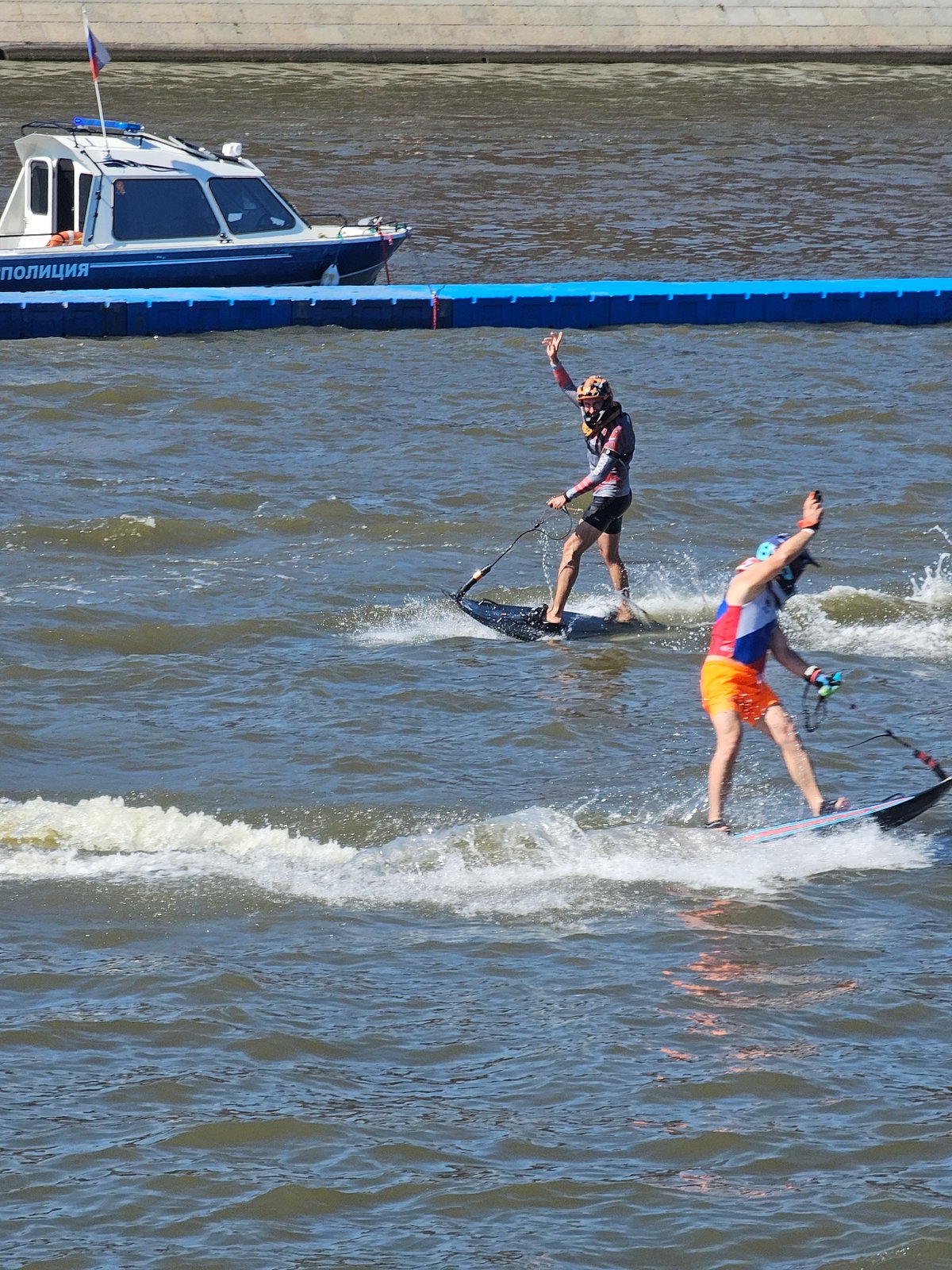 Multiple water sports disciplines going off near a city waterfront