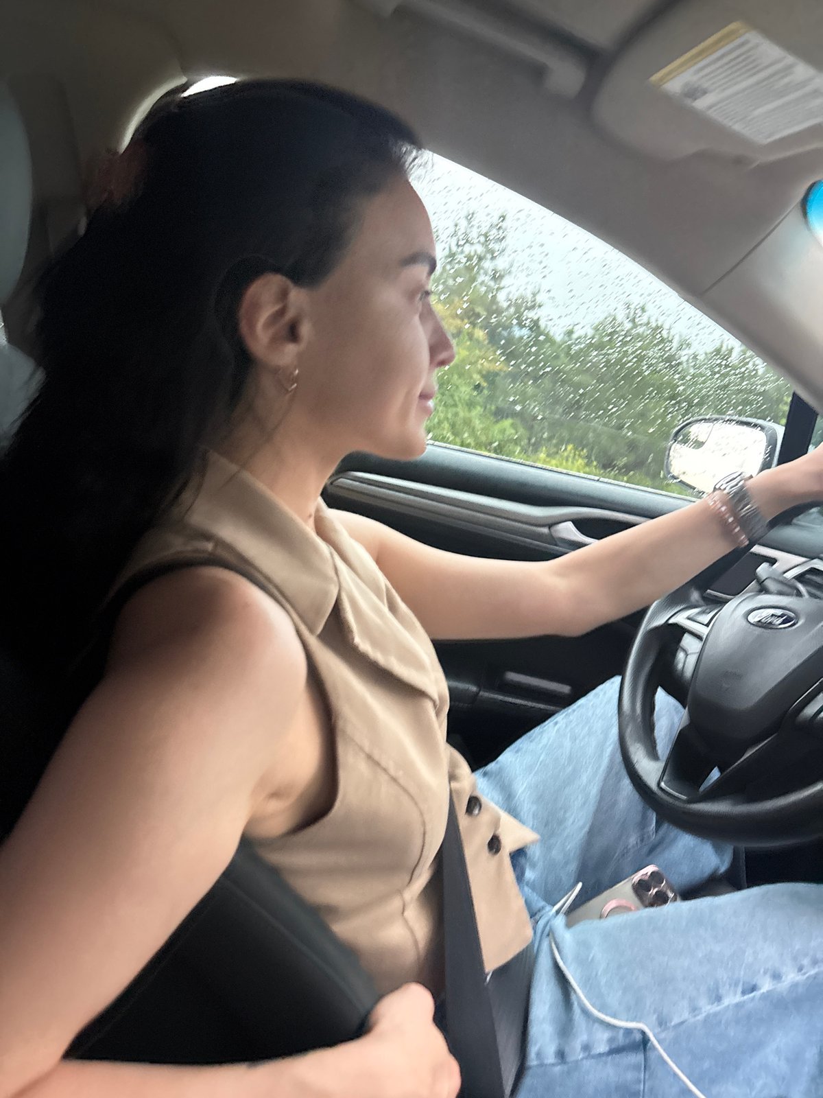Woman drives through rainy Tbilisi on overcast afternoon