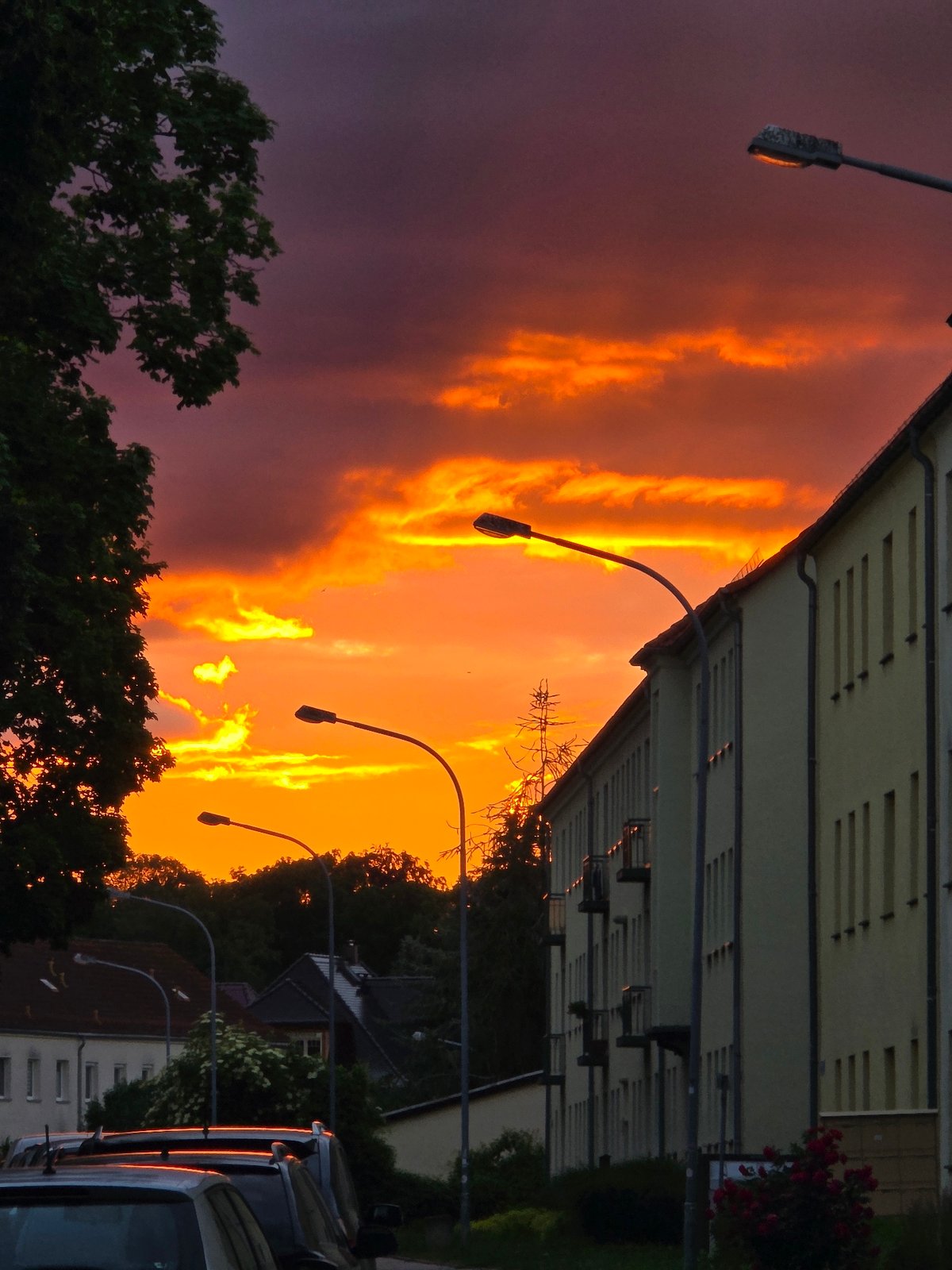 Dramatic purple sky observed over residential street during twilight