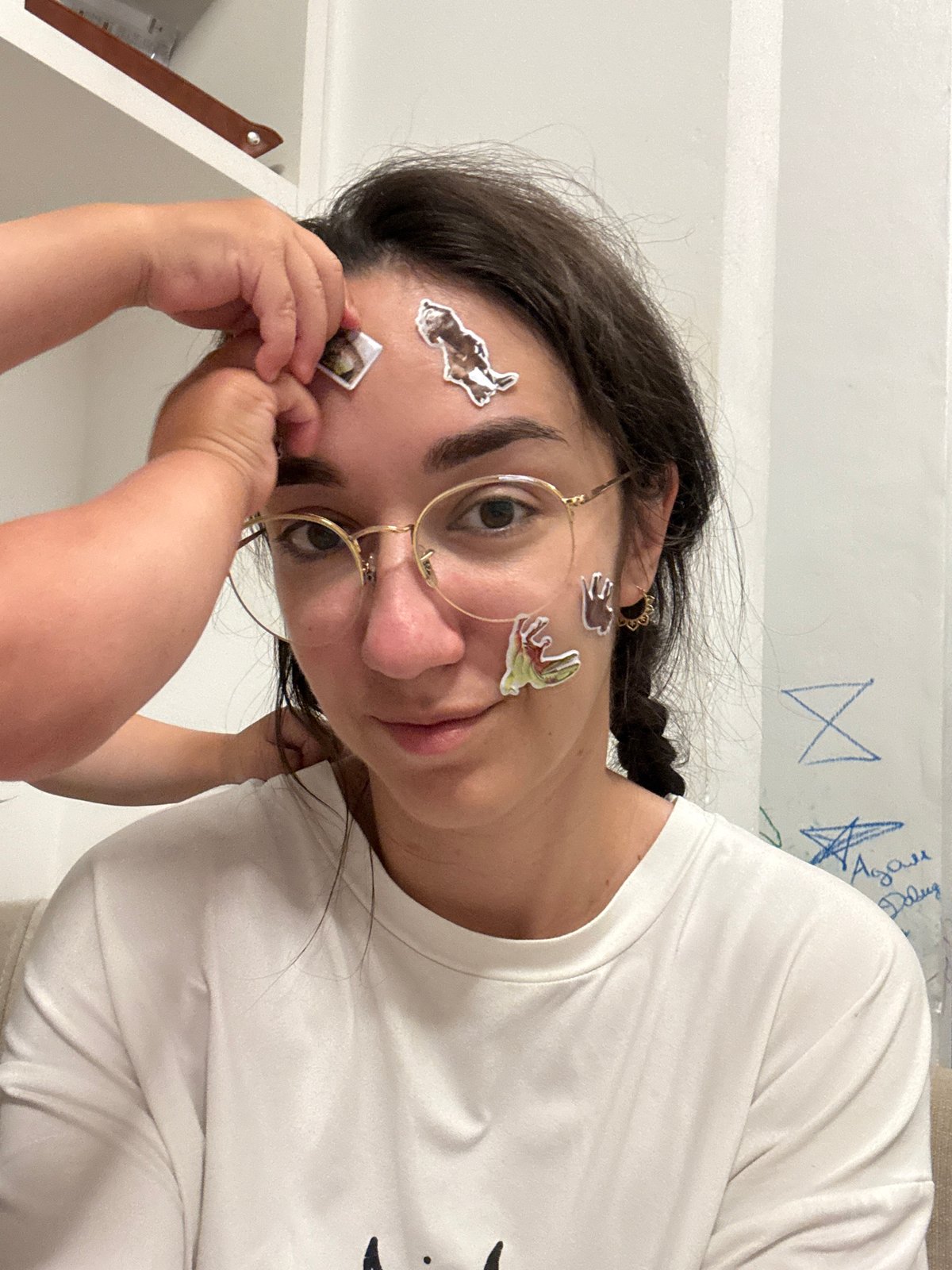 Woman with stickers on face photographed in children's room